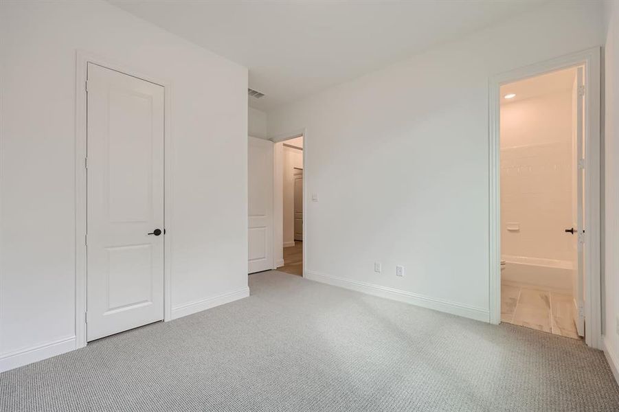 Unfurnished bedroom featuring connected bathroom and carpet floors