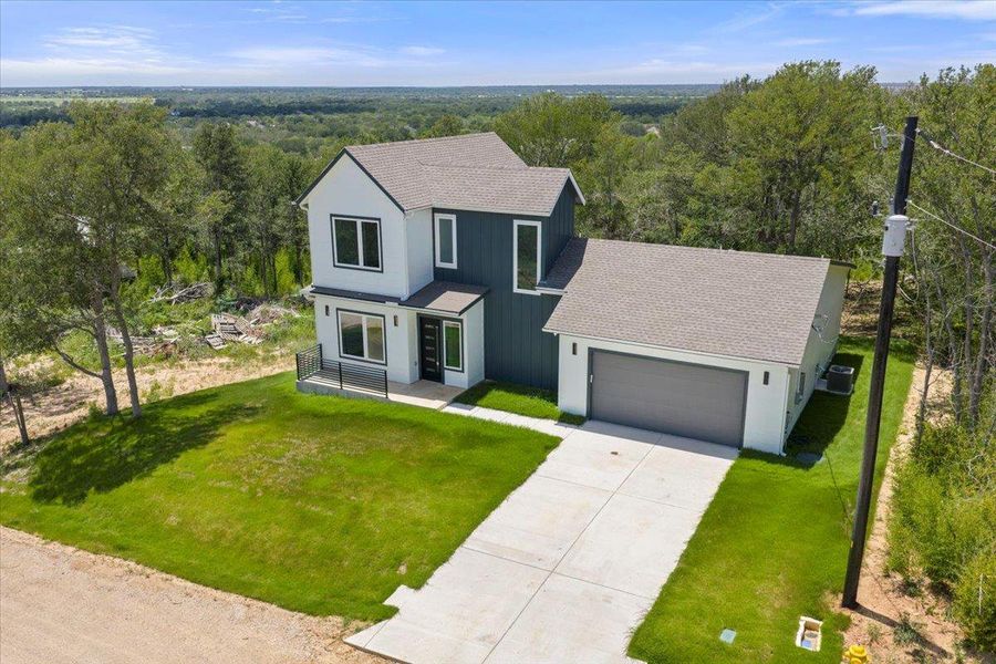 View of front of house featuring an attached garage, driveway, roof with shingles, and a front yard View of front of house featuring an attached garage, driveway, roof with shingles, and a front yard