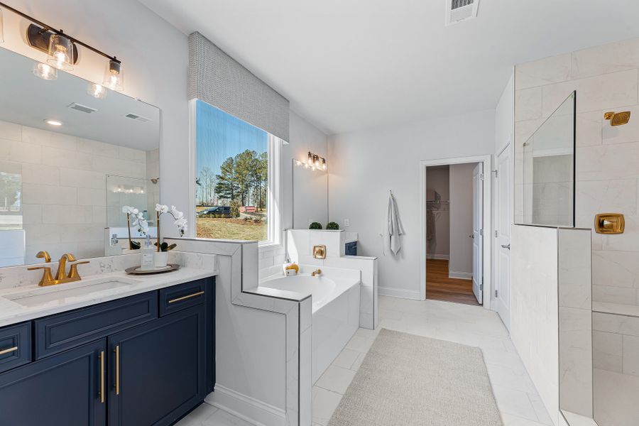 A bathroom with a tub sink and cabinets.