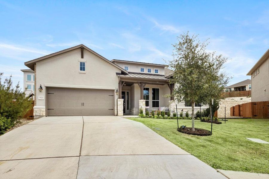 View of front of home with fence, driveway, a standing seam roof, a front lawn, and metal roof