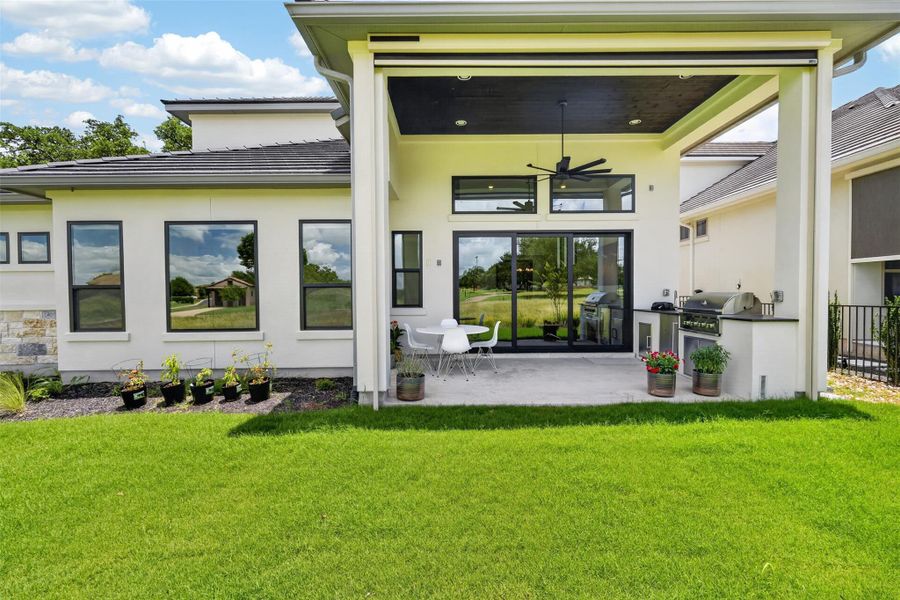 A spacious covered patio offers an outdoor kitchen for al fresco entertaining, overlooking the verdant yard. A spacious covered patio offers an outdoor kitchen for al fresco entertaining, overlooking the verdant yard.