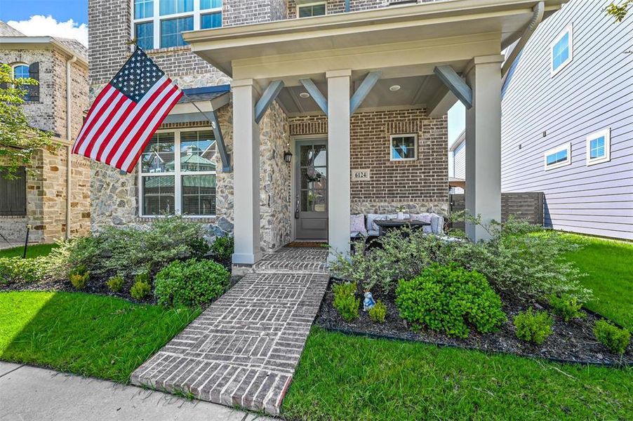 View of exterior entry with brick siding, stone siding, and covered porch View of exterior entry with brick siding, stone siding, and covered porch