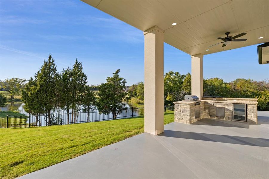 View of patio with ceiling fan, a water view, and area for grilling