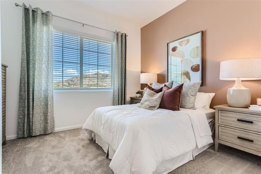 Bedroom featuring multiple windows and light carpet