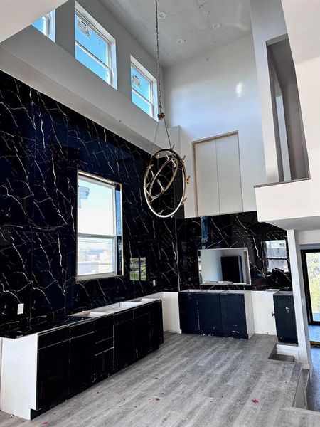 Kitchen featuring a towering ceiling and light wood-type flooring (laminate)