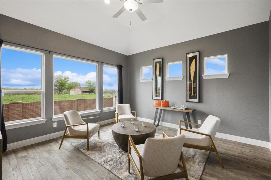 Living area featuring lofted ceiling, hardwood / wood-style flooring, and ceiling fan