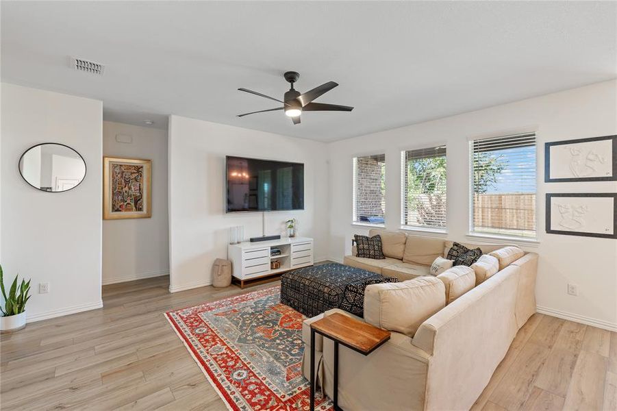 Living room with light hardwood / wood-style floors and ceiling fan