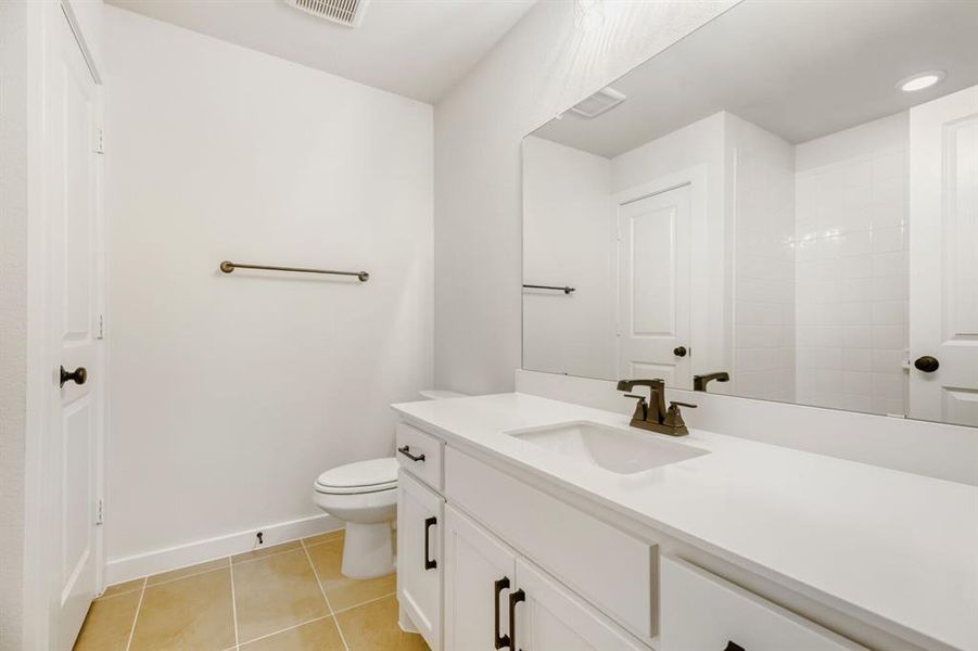 Bathroom vanity featuring a single sink, white countertop, and dark-bronze-finish faucet
