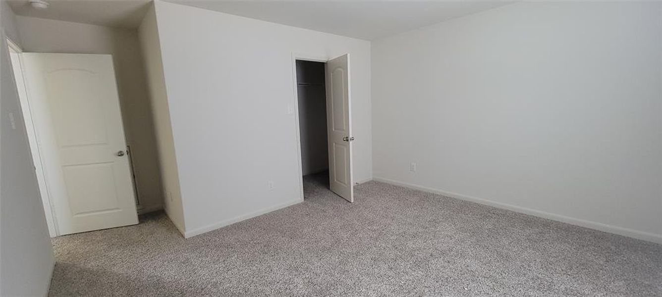 Unfurnished bedroom featuring a closet and light colored carpet