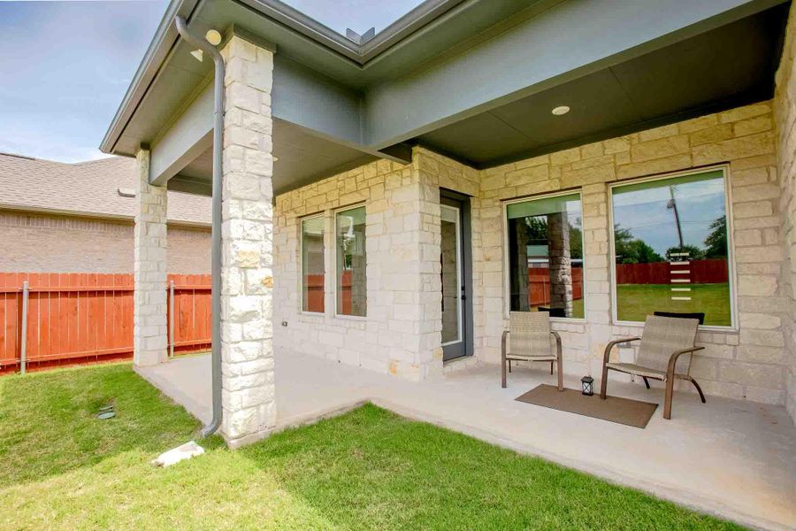 Covered patio featuring stone columns and light-colored masonry siding