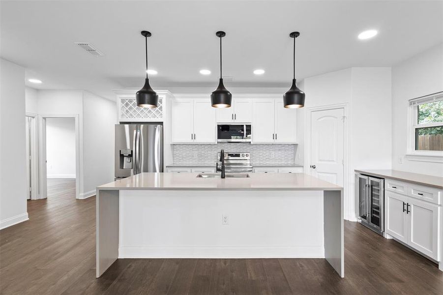Kitchen featuring light stone counters, tasteful backsplash, white cabinets, dark wood-style flooring, and recessed lighting