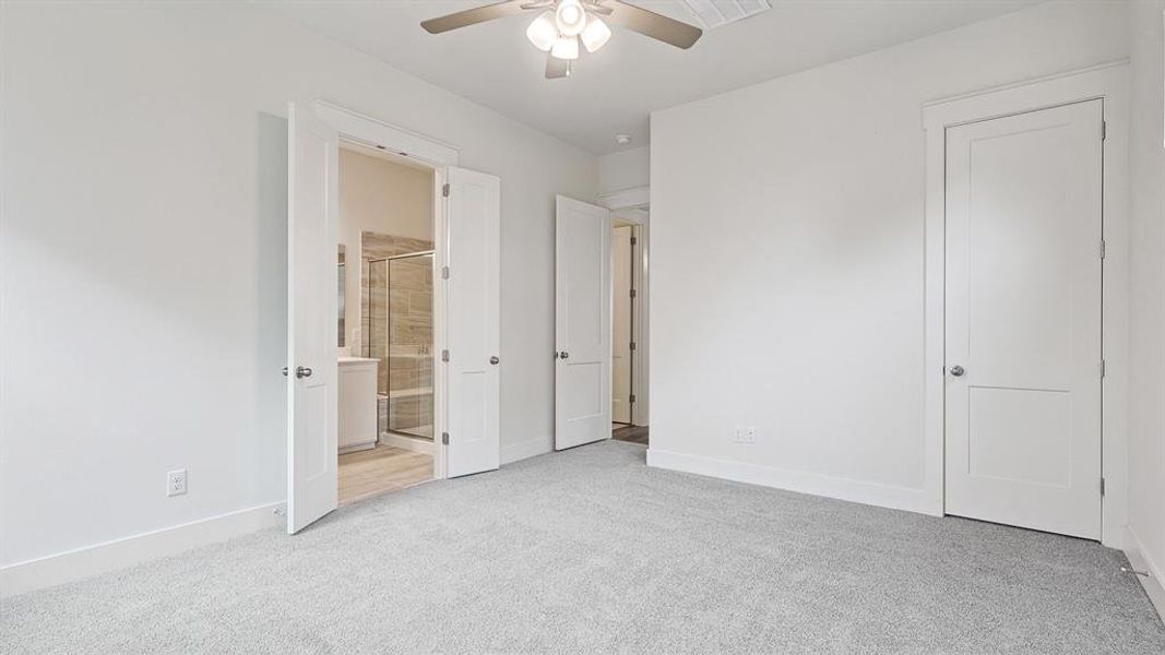 Carpeted room with a ceiling fan, white walls, and white trim