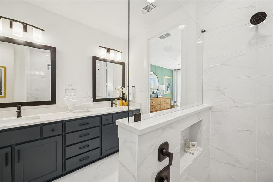 Dual vanity with dark cabinetry, white countertops, and framed mirrors