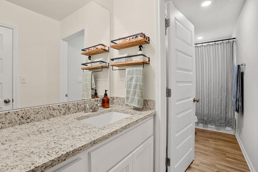 Granite counters and crisp white cabinetry create a pristine and functional bathroom space.