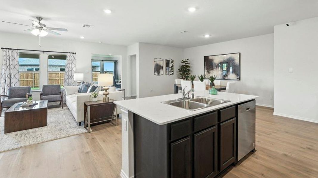 Kitchen with open floor plan, a kitchen island with sink, a ceiling fan, light wood-style flooring, and dishwasher Kitchen with open floor plan, a kitchen island with sink, a ceiling fan, light wood-style flooring, and dishwasher