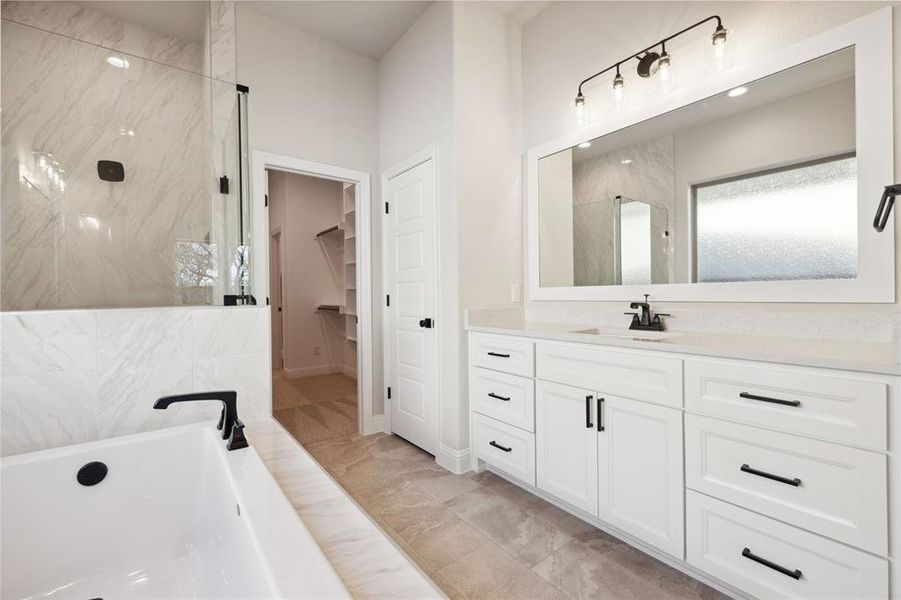 Bathroom featuring shower with separate bathtub and vanity