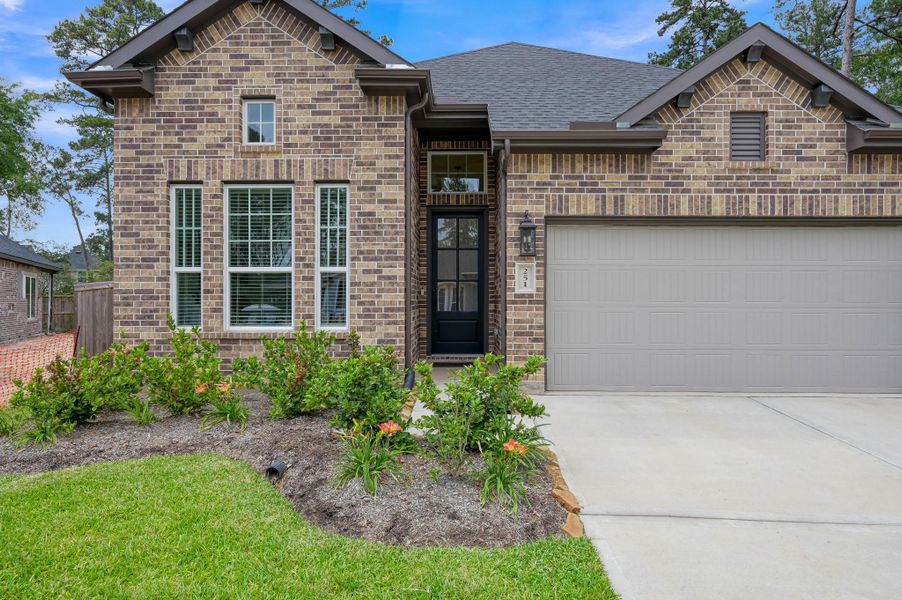Alternate exterior view showcasing the spacious driveway, oversized garage with added 5-foot storage extension, and elegant architectural details that make this home stand out.