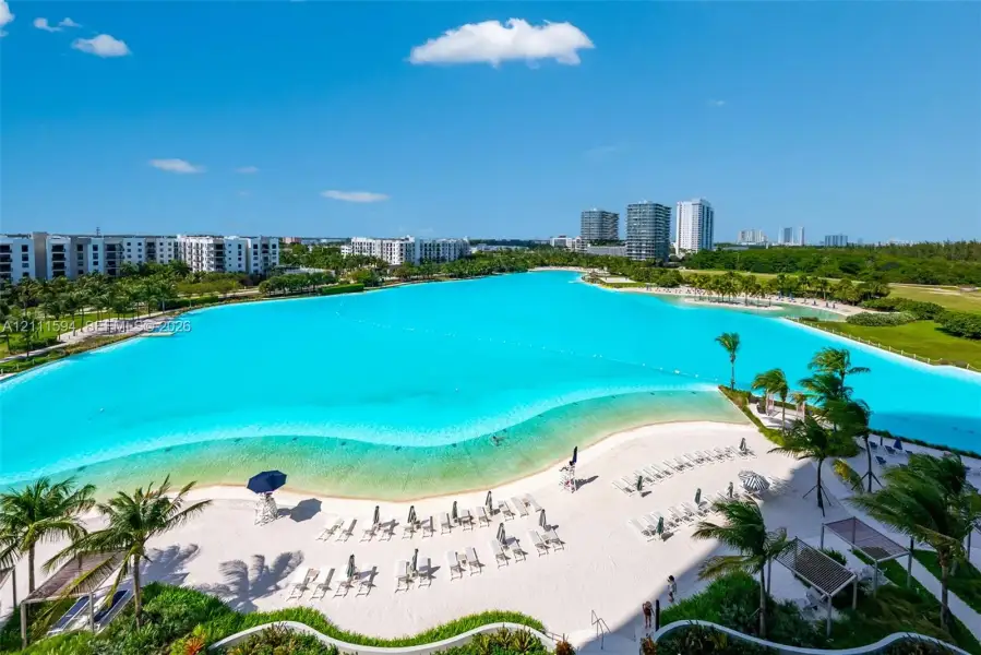 Expansive turquoise lagoon, white sand beach, and tropical landscaping Expansive turquoise lagoon, white sand beach, and tropical landscaping