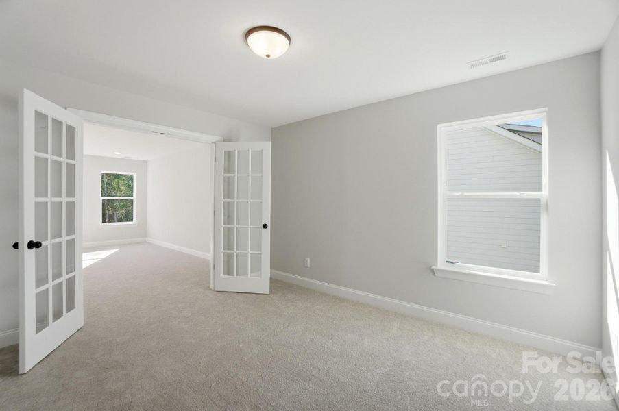 Sitting room with French doors connected to primary bedroom