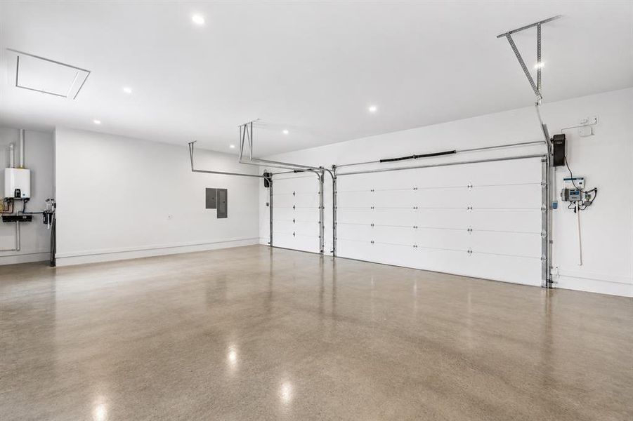 An oversized 3 car garage with polished concrete floors, Chamberlain side mount openers, Navien tankless hot water heater, EV charger, whole home water filter, and Hunter sprinkler system controls, as well as attic access for more storage.