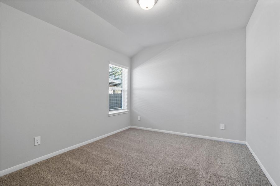 This cozy secondary bedroom offers plush soft carpeting, neutral walls, a large window with fitted blinds, sloped ceilings, and a spacious walk-in closet for all your storage needs. This cozy secondary bedroom offers plush soft carpeting, neutral walls, a large window with fitted blinds, sloped ceilings, and a spacious walk-in closet for all your storage needs.