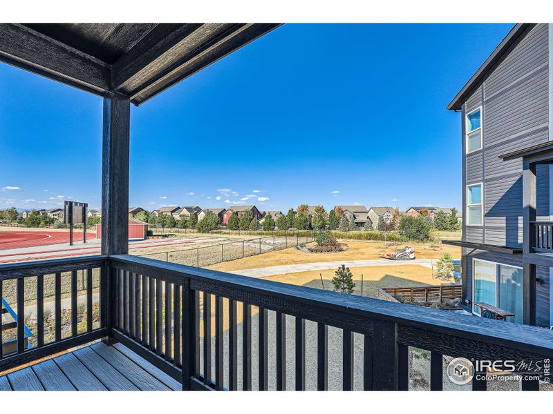 The balcony off the kitchen overlooks a high--school field and mountain views.