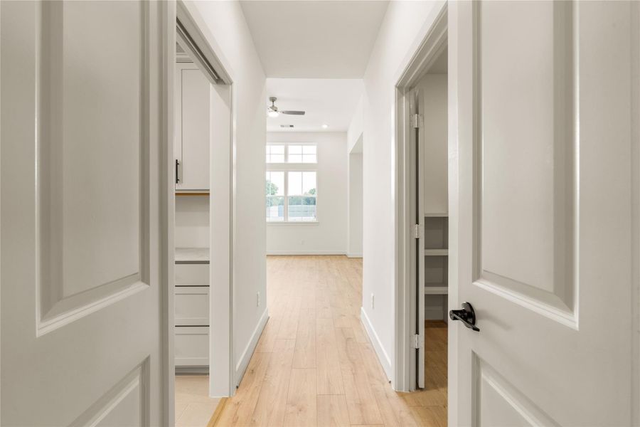 Primary suite private hallway — direct door access connecting the bedroom suite, laundry area, and walk-in closet.