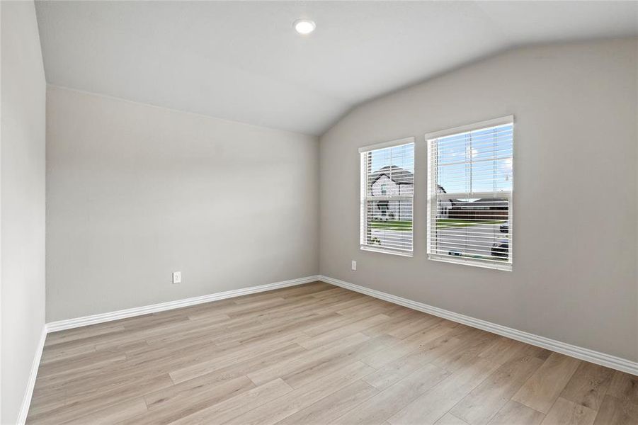Empty room with vaulted ceiling and light wood finished floors Empty room with vaulted ceiling and light wood finished floors