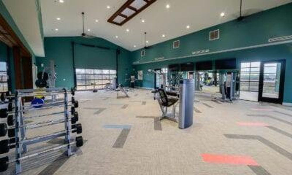 Exercise room with carpet floors and high vaulted ceiling