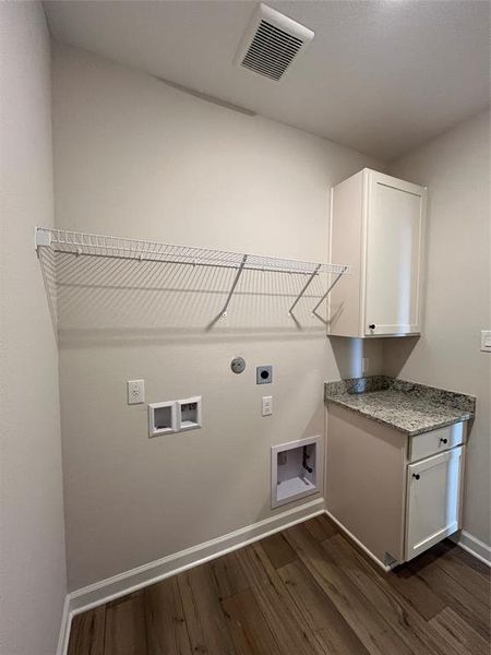 The downstairs utility room features built in shelving and cabinets.