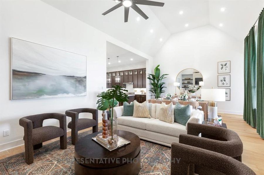 Living room featuring light wood-style floors, high vaulted ceiling, ceiling fan, and recessed lighting
