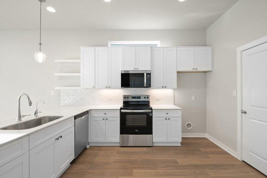 Kitchen featuring white cabinetry, open shelves, stainless steel appliances, decorative light fixtures, and dark wood-style floors