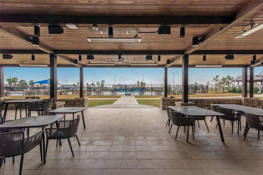 Experience a stunning view of the clubhouse from the covered seating area, perfect for relaxation and social gatherings.