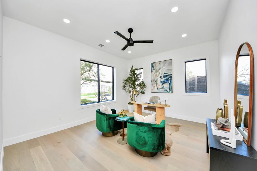 Bright and private workspace with multiple windows and a sleek black ceiling fan!
