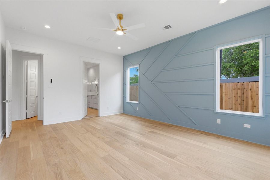 Primary suite on the first level. Complete with an accent wall, recessed lighting, and a spacious en-suite.
