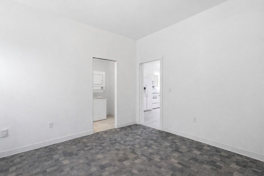 This room features clean white walls and a gray patterned carpet