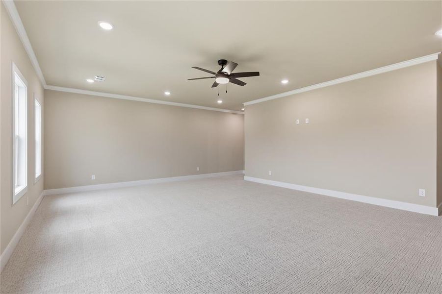 Expansive room featuring light-toned carpeting, ample recessed lighting, a ceiling fan, and multiple windows Expansive room featuring light-toned carpeting, ample recessed lighting, a ceiling fan, and multiple windows