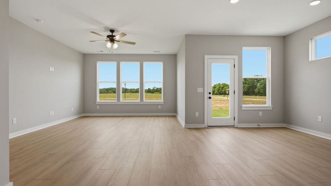 Gathering and dining area with access to back entry and bright natural light through windows Gathering and dining area with access to back entry and bright natural light through windows