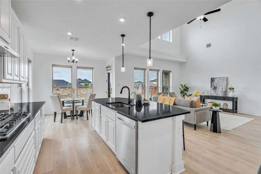 A well-lit open concept living area boasts a modern kitchen island and inviting dining space.