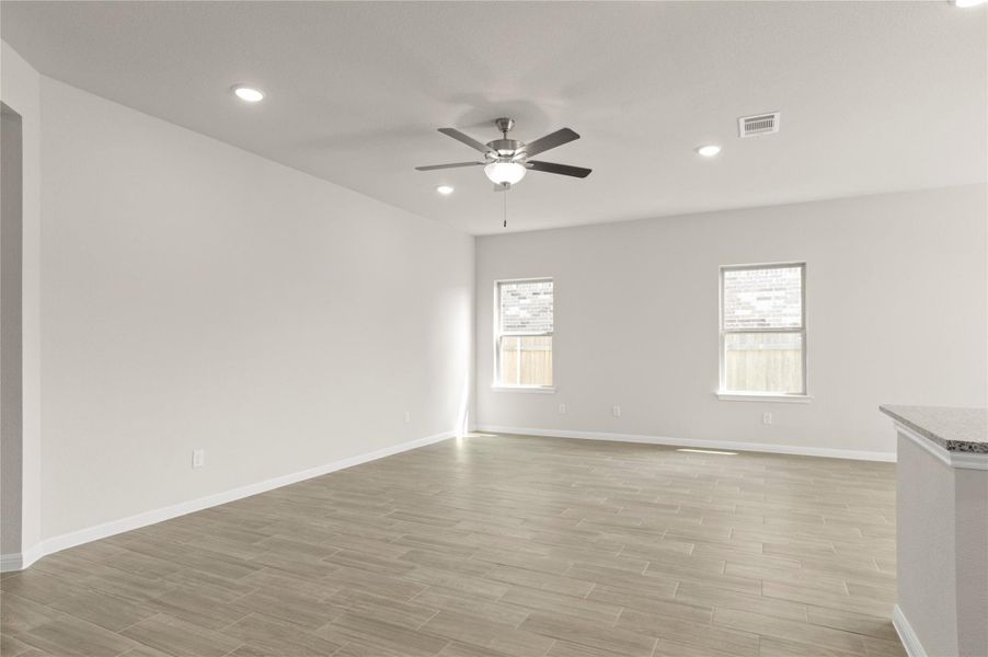 Spare room with a ceiling fan, light wood-style flooring, and recessed lighting