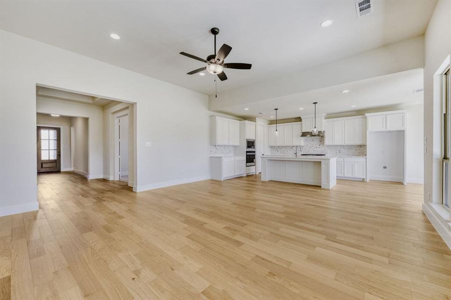 Unfurnished living room featuring ceiling fan, light wood finished floors, and recessed lighting