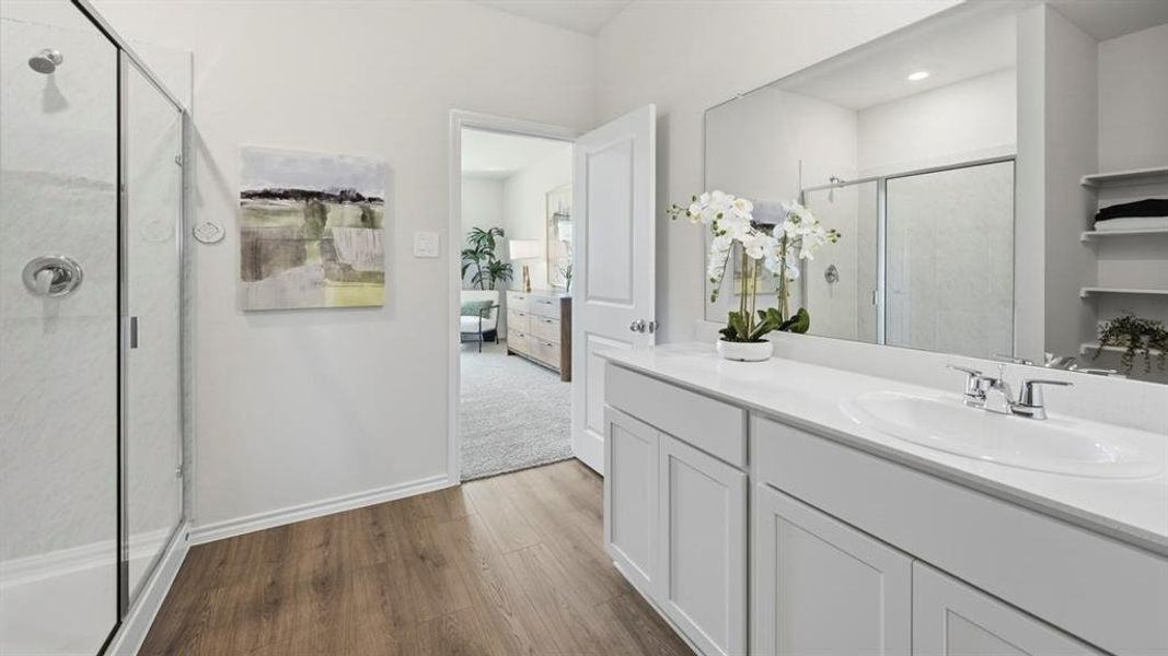 Ensuite bathroom with a shower stall, vanity, and dark wood-style flooring Ensuite bathroom with a shower stall, vanity, and dark wood-style flooring