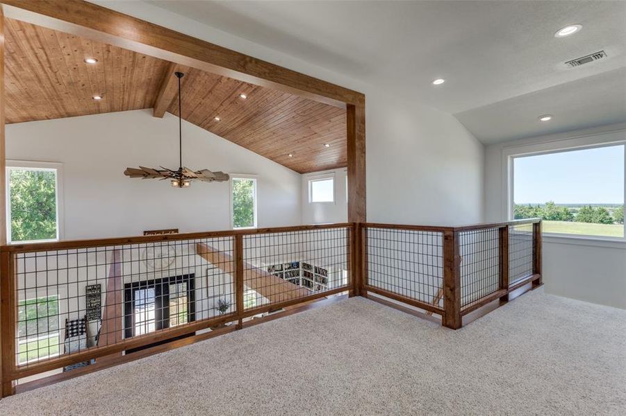 Hallway with carpet, lofted ceiling with beams, and a healthy amount of sunlight Hallway with carpet, lofted ceiling with beams, and a healthy amount of sunlight