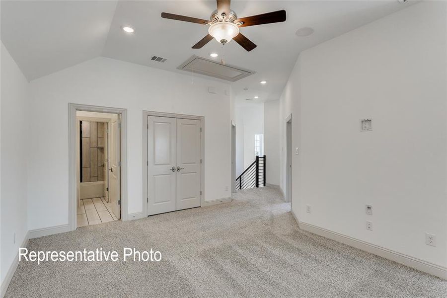 Carpeted spare room featuring ceiling fan and vaulted ceiling