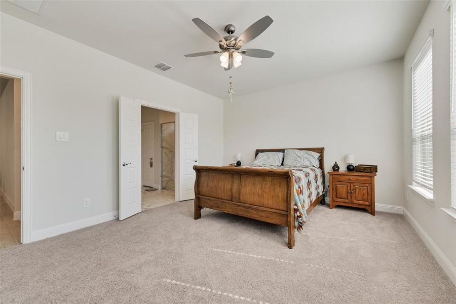 Primary Bedroom with light colored carpet, a ceiling fan, and ensuite bathroom Primary Bedroom with light colored carpet, a ceiling fan, and ensuite bathroom