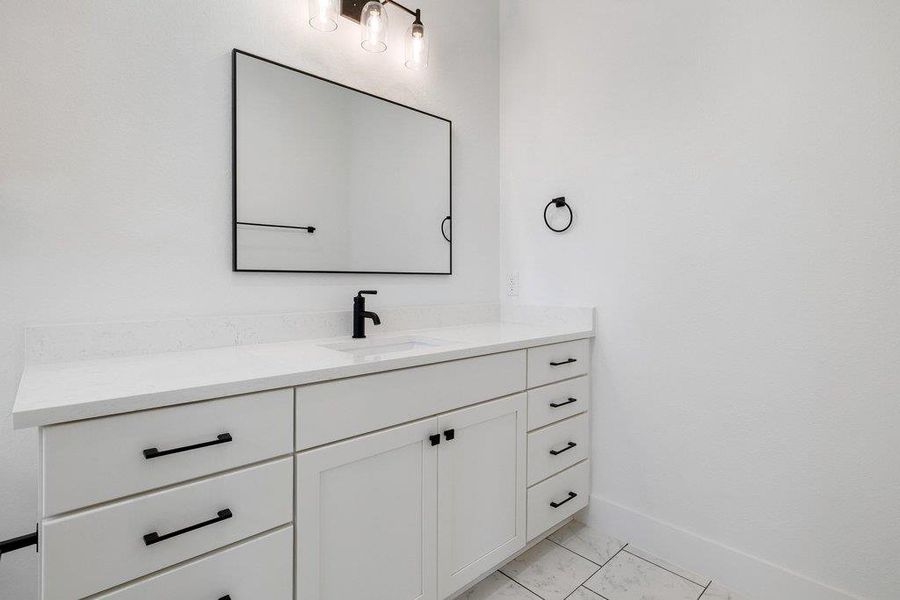 Bathroom featuring vanity and baseboards