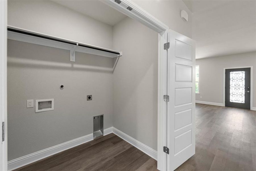 Clothes washing area featuring hookup for an electric dryer, dark hardwood / wood-style floors, and washer hookup