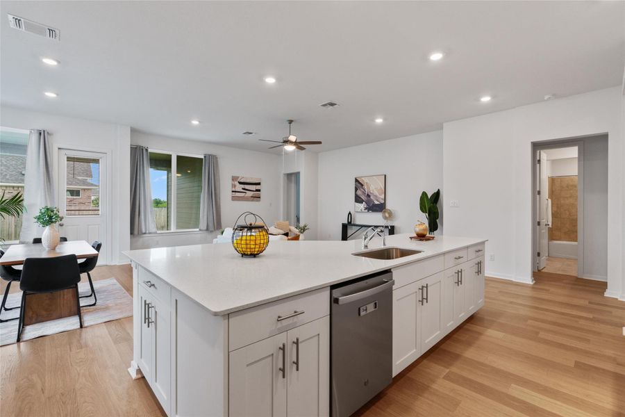 An open concept design flows seamlessly from kitchen to dining and living areas, anchored by a central island.