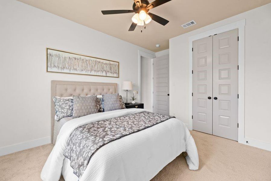 Bedroom with light colored carpet, a ceiling fan, and a closet Bedroom with light colored carpet, a ceiling fan, and a closet
