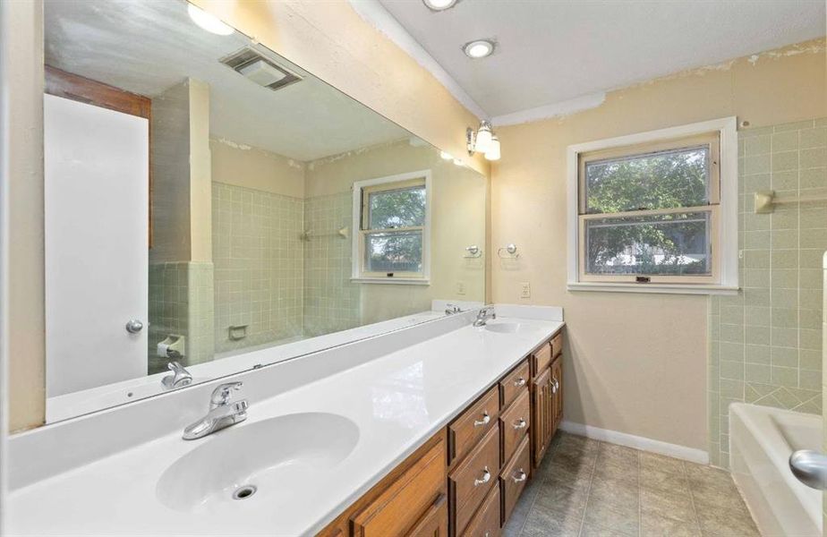 Full bath featuring double vanity, shower / bath combination, and recessed lighting